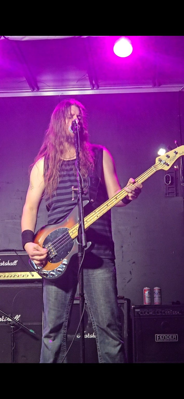 AC/DC ERAS bassist performing under purple stage lights